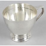 An early 20th century silver christening mug of plain form standing on a footed base with inscribed