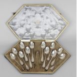 A cased 'sample' selection of twelve George V silver teaspoons and a pair of sugar tongs,