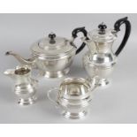 A modern silver four piece tea set of round bulbous form with pie crust decoration standing on