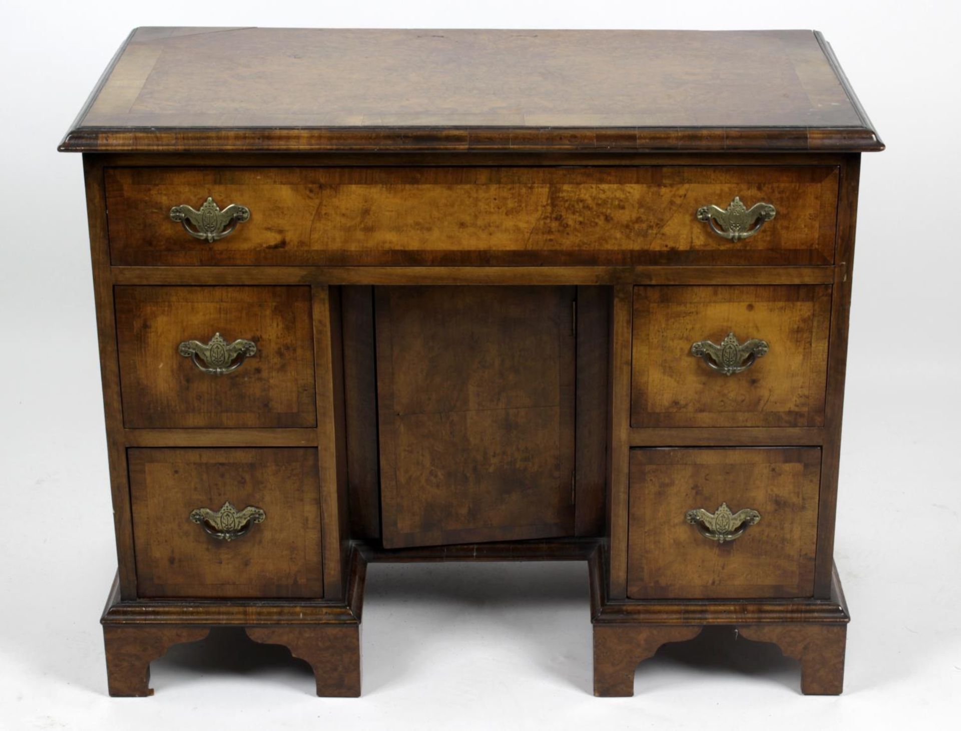 A reproduction walnut and mahogany crossbanded kneehole desk,