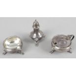A modern silver three piece condiment set with pie crust rim and standing on three hoof feet -