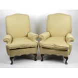 A pair of yellow upholstered armchairs,
