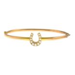 An early 20th century 15ct gold split pearl horseshoe hinged bangle.Stamped 15ct.