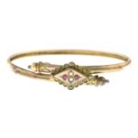 An early 20th century 9ct gold split pearl and red gem bangle.Stamped 9ct.