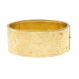 A bangle, with engraved detail.Stamped 9CT.