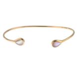 A cuff bangle, with mother-of-pearl terminals.Stamped 14K.