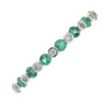 An 18ct gold diamond and emerald half eternity ring.Total diamond weight 0.05ct,