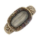 A late Georgian floral embossed mourning ring, with glazed panel.Ring size Q.