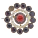 An early 20th century 9ct gold garnet and white enamel brooch.One garnet deficient.