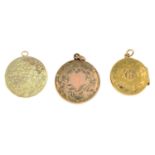 Three engraved circular locket pendants.