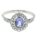 A sapphire and brilliant-cut diamond cluster ring.Sapphire weight 1.05cts.Total diamond weight