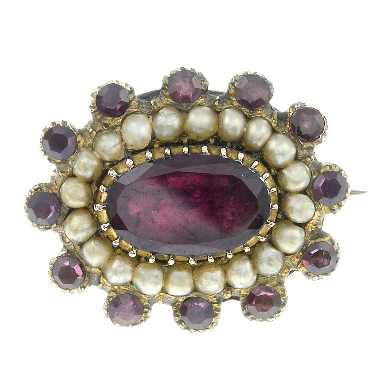 A late 19th century garnet and split pearl brooch.Length 2cms.