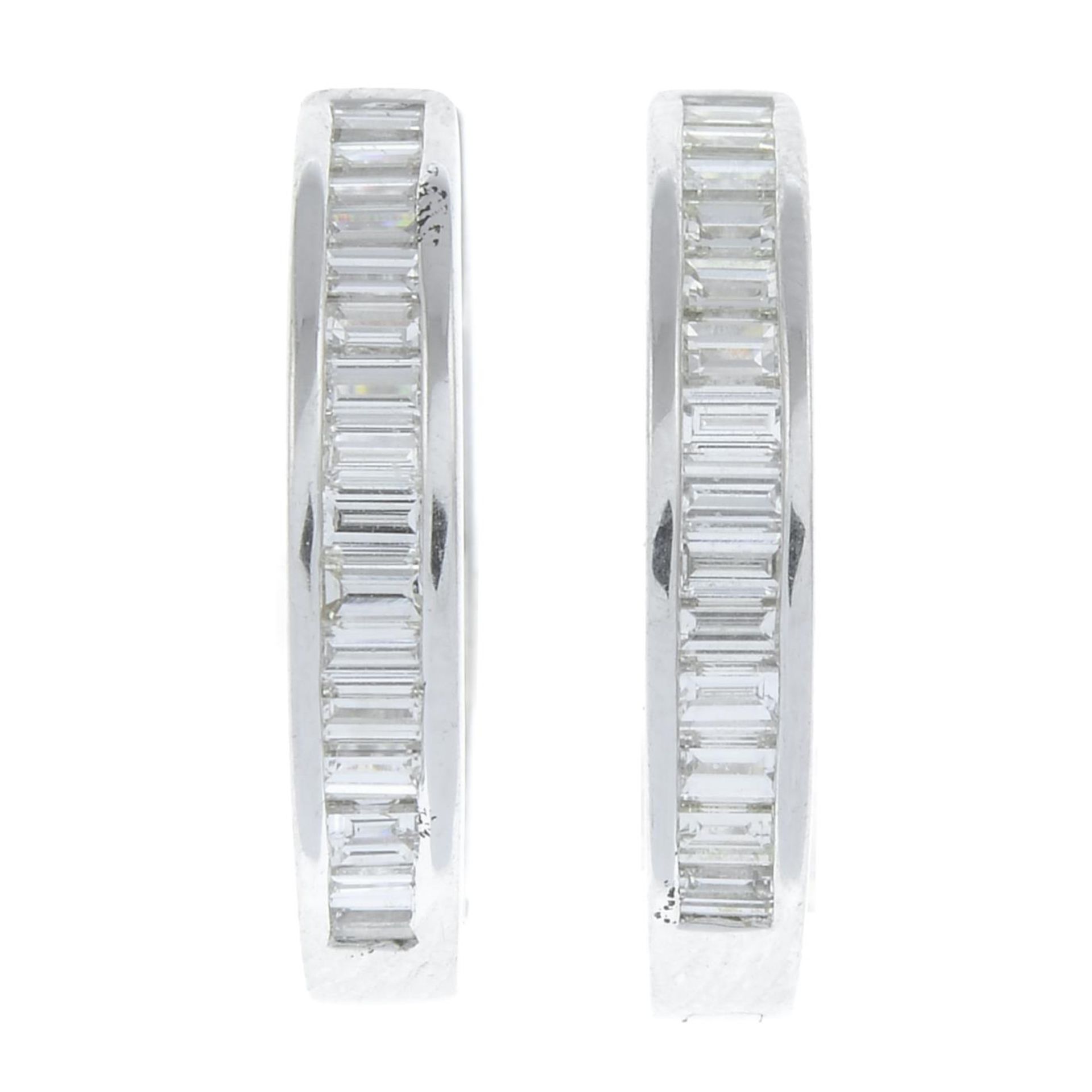 A pair of 18ct gold baguette-cut diamond hoop earrings.Estimated total diamond weight