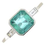 An emerald single-stone ring, with baguette-cut diamond shoulders.