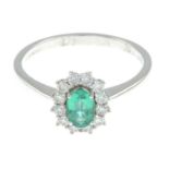 An 18ct gold emerald and brilliant-cut diamond cluster ring.Emerald weight 0.42ct.Total diamond