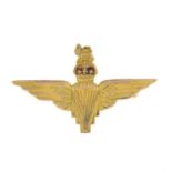 A 1950s 9ct gold Parachute Regiment brooch, with red enamel accent.Hallmarks for Birmingham, 1959.