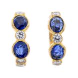 A pair of diamond and sapphire hoop earrings.Estimated total diamond weight 0.40ct.