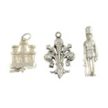 A selection of charms, to include a charm of a castle guard, a fleur-de-lis and a castle.