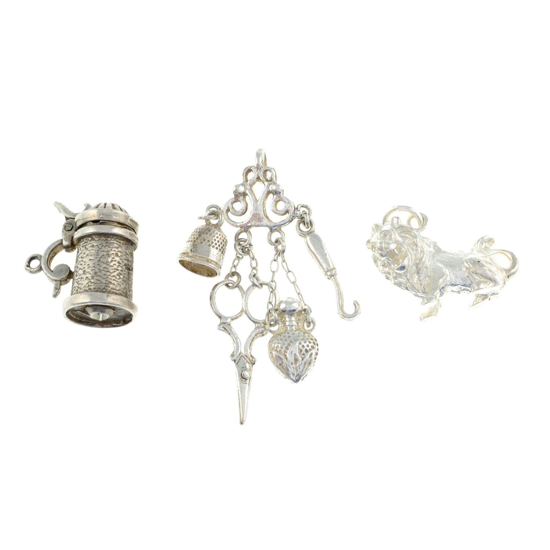 A selection of charms, to include a charm of a tankard, a chatelaine and a lion.