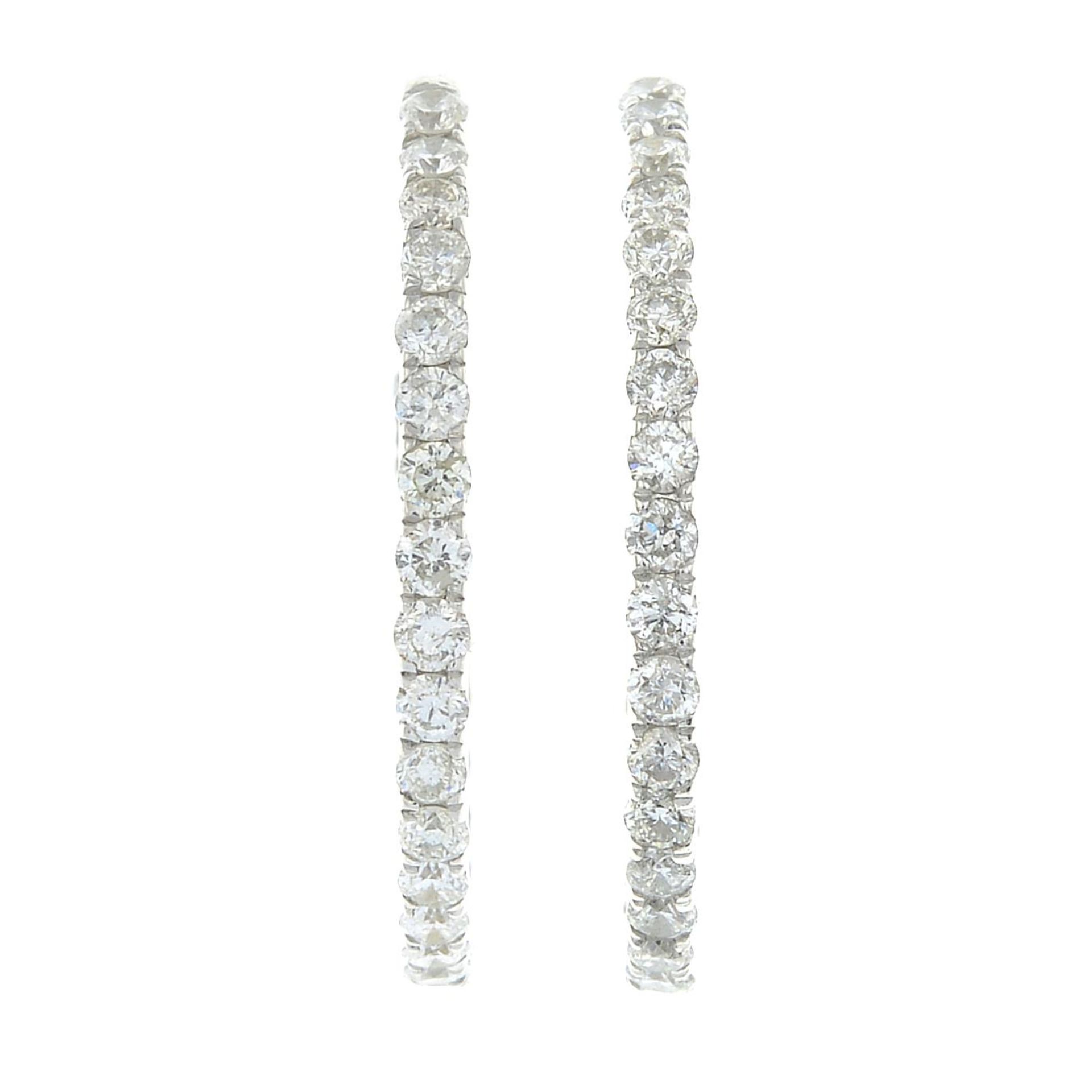 A pair of 9ct gold brilliant-cut diamond hoop earrings.