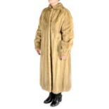 A full-length collarless honey blonde mink coat.