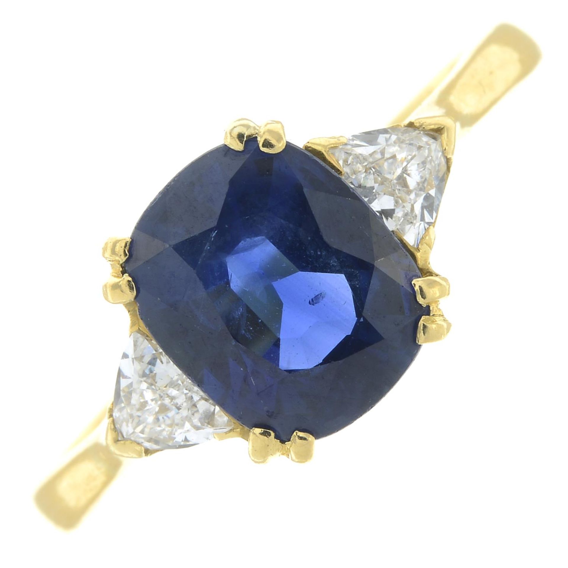 An 18ct gold sapphire and triangular-shape diamond three-stone ring.Sapphire calculated weight