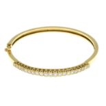 An 18ct gold brilliant-cut diamond bangle, hinged to the plain reverse.