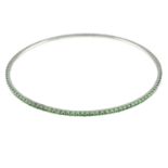 An 18ct white gold tsavorite garnet bangle.Hallmarks for Birmingham.Inner diameter 6.5cms.