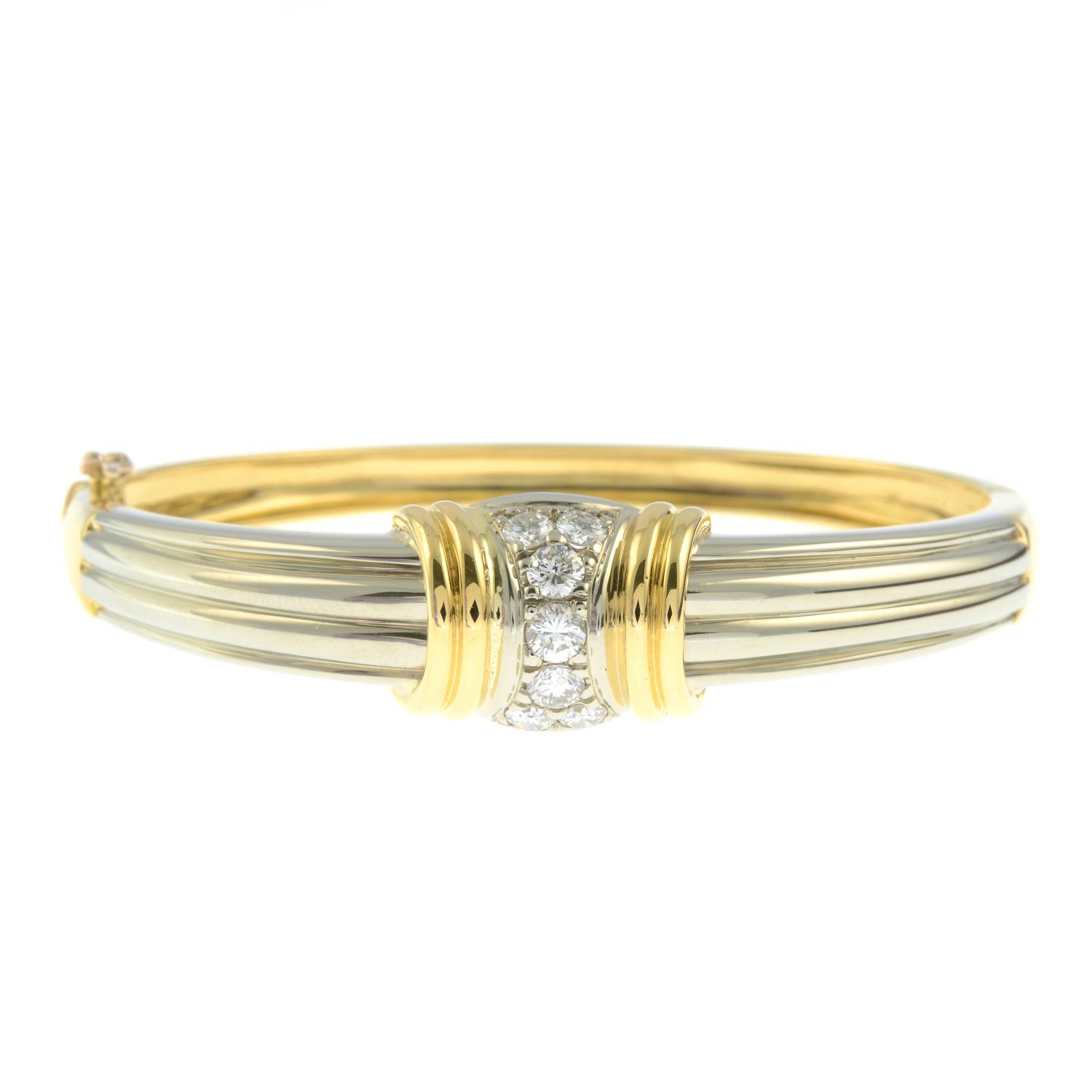 A brilliant-cut diamond bi-colour hinged bangle.Total diamond weight 0.87ct,