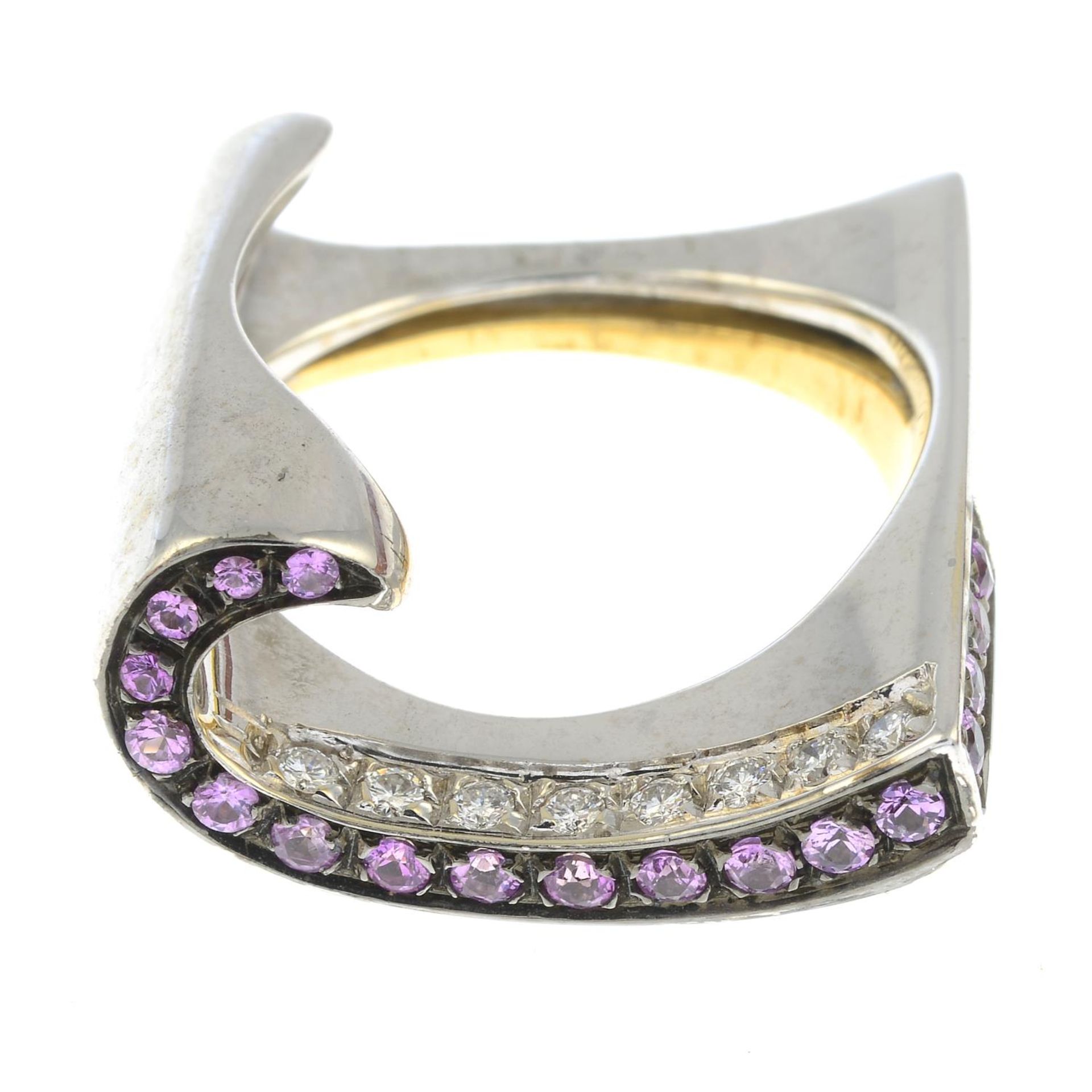 An 18ct gold pink sapphire and brilliant-cut diamond scroll ring.Estimated total diamond weight