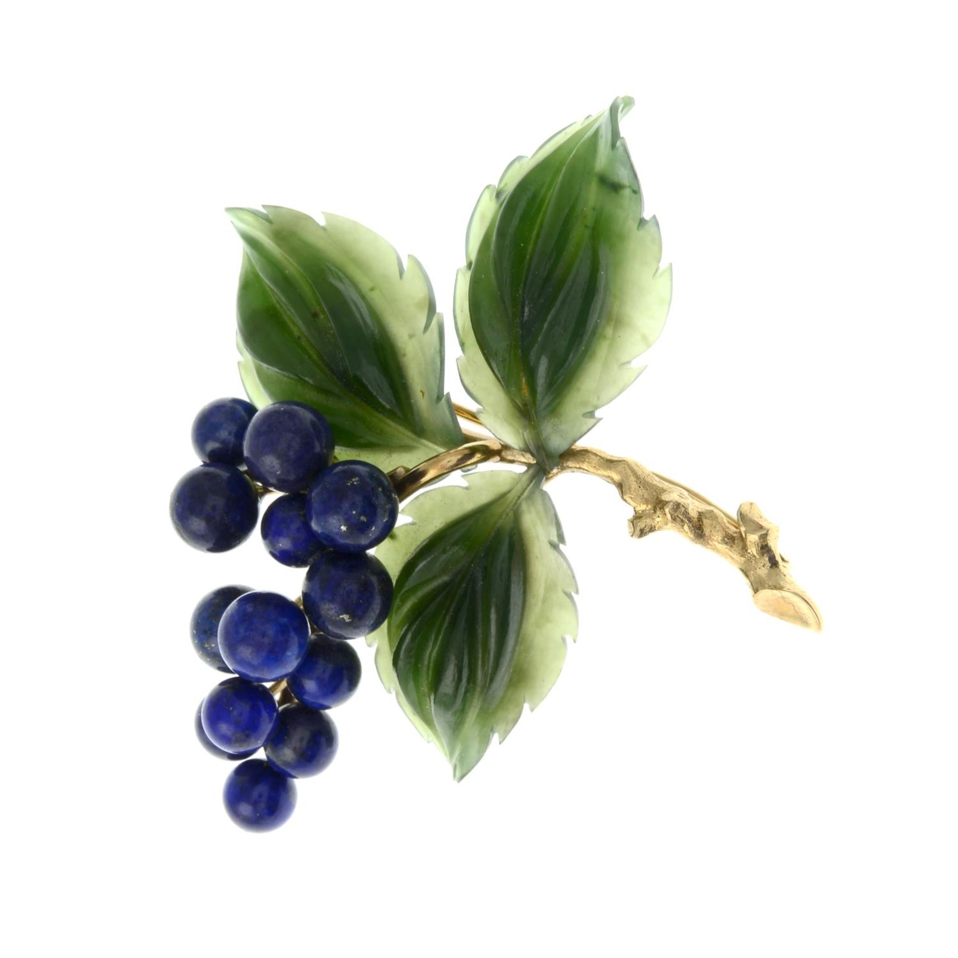 A brooch, with carved nephrite jade leaves, with lapis lazuli berries.Stamped 585.Length 5.2cms.