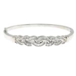 A brilliant and baguette-cut diamond bangle, hinged to the plain reverse.