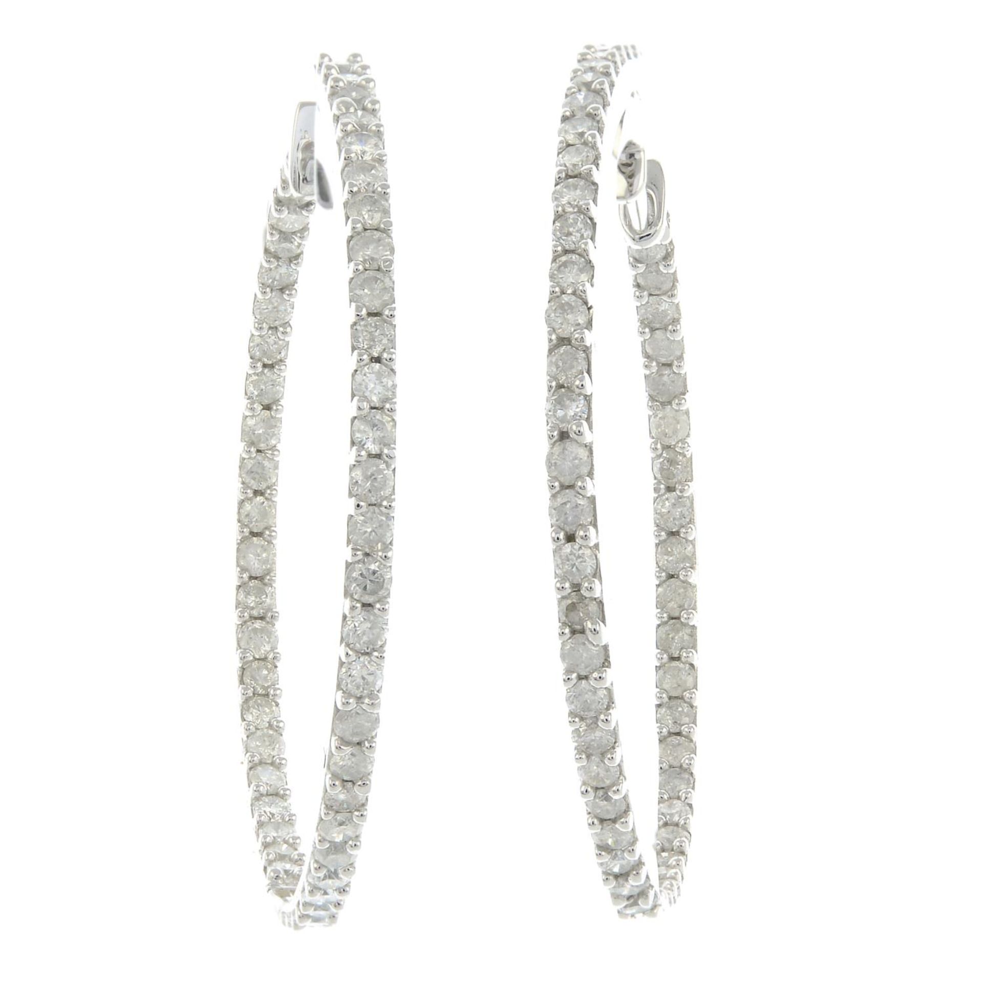 A pair of diamond hoop earrings.