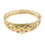 An Edwardian 9ct gold bangle, with diamond and garnet-topped-doublet highlights.