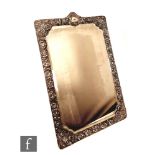 An Edwardian hallmarked silver mounted easel table mirror with embossed and foliate engraved border,