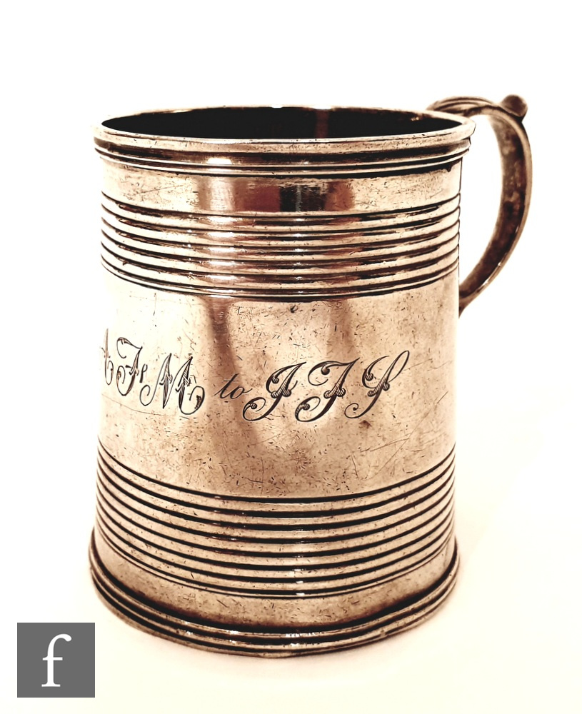 A George II hallmarked christening tankard of plain form with reeded band decorations and acanthus