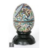 A Russian silver and cloisonne enamelled Easter egg in tonal green, blue and red foliate scrolls,