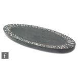 Martin Cook (B. 1958) - An elongated oval carved slate shallow dish, the rim engraved with the motto