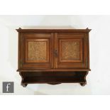 Unknown ? An Aesthetic movement walnut two door wall cabinet with carved oak panels below single