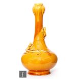 Maw & Co - An early 20th Century bottle vase glazed in mustard yellow with two applied lizards to