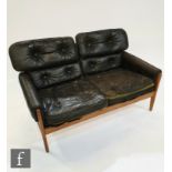 Attributed to Parker Knoll - A black button down leather and teak framed two seat sofa, A/F.