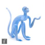 Bimini - A 1930s lampworked glass figure of a seated monkey with outstretched paw, in opaque blue,