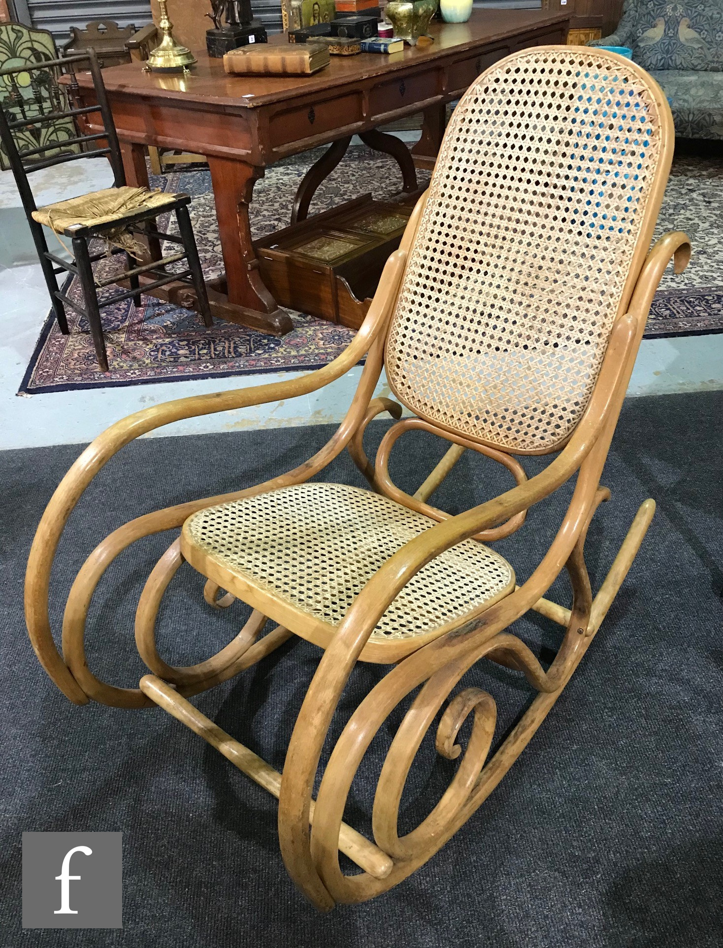 Thonet - A bentwood and bergere canework panelled rocking armchair of scroll design, bears Thonet