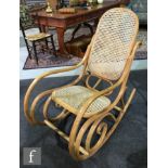 Thonet - A bentwood and bergere canework panelled rocking armchair of scroll design, bears Thonet