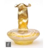 In the manner of Loetz - An early 20th Century Bohemian glass vase of compressed and dimpled form