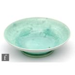 Ruskin Pottery - A small footed bowl decorated in an all over pale green souffle glaze, impressed