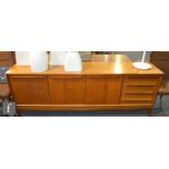 Alfred Cox Furniture - A teak sideboard fitted with an arrangement of three doors and four drawers