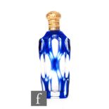 A late 19th Century scent bottle with blue flash cut glass below gilt collar and hinged cap,