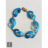 A Norwegian silver bracelet comprising six blue enamelled stylised scroll panels terminating in