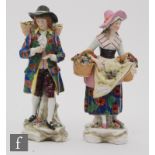 A pair of 20th Century continental figures of flower sellers, both unmarked but with spurious